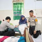anggota polisi sedang membagikan sembako ke nenek-nenek lanjut usia
