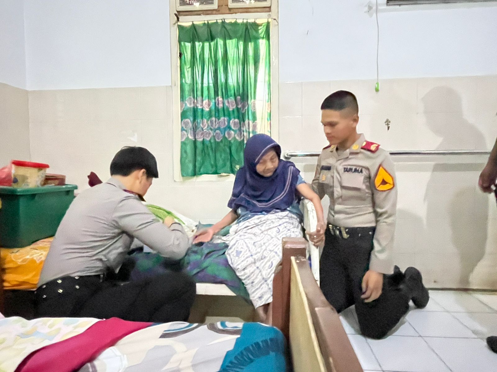 anggota polisi sedang membagikan sembako ke nenek-nenek lanjut usia