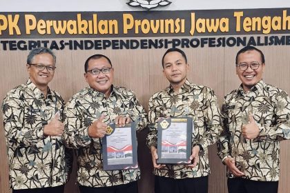 Perwakilan Pemkot Solo dan pejabat BPK memegang map dokumen laporan LHP LKPD saat penyerahan opini WTP di kantor BPK Jawa Tengah
